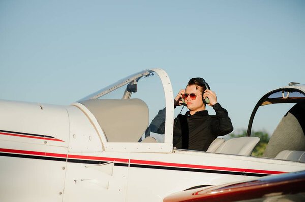 Portrait of confident young man pilot in small plane