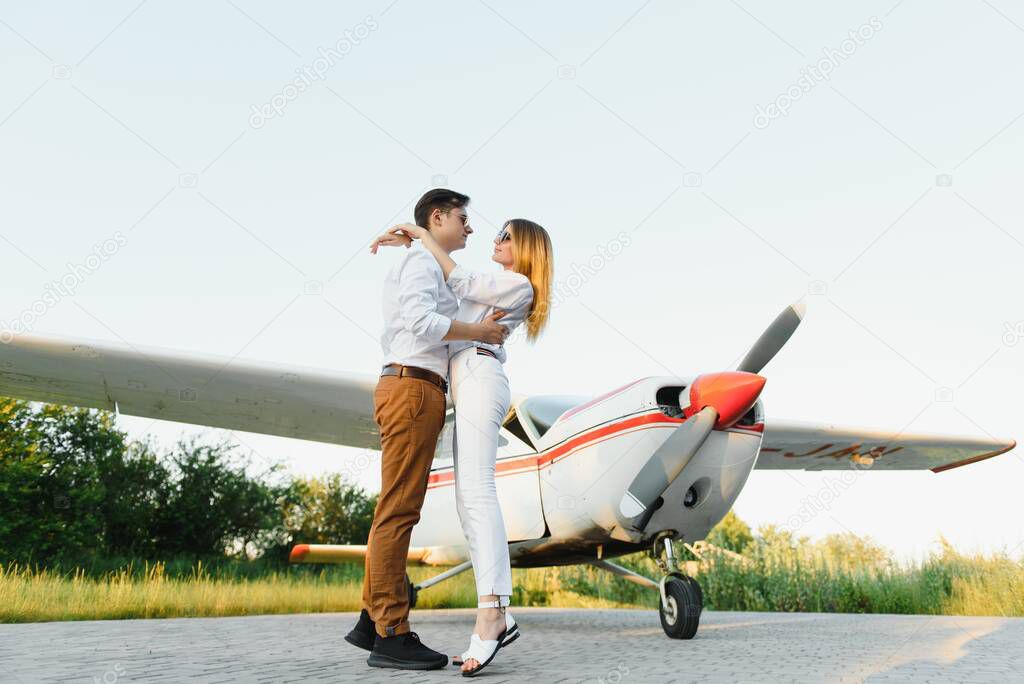 Couple in love having fun near private plane.