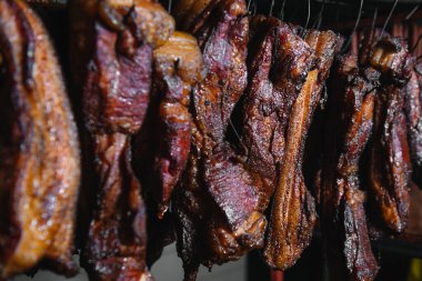 Geleneksel tütsülenmiş et. Siyah arka planda tütsülenmiş salam kompozisyonu.