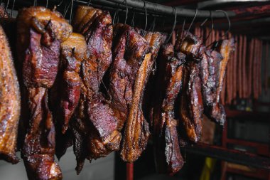 Geleneksel tütsülenmiş et. Siyah arka planda tütsülenmiş salam kompozisyonu.