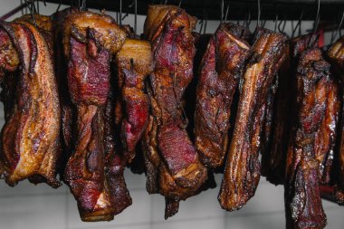 Geleneksel tütsülenmiş et. Siyah arka planda tütsülenmiş salam kompozisyonu.