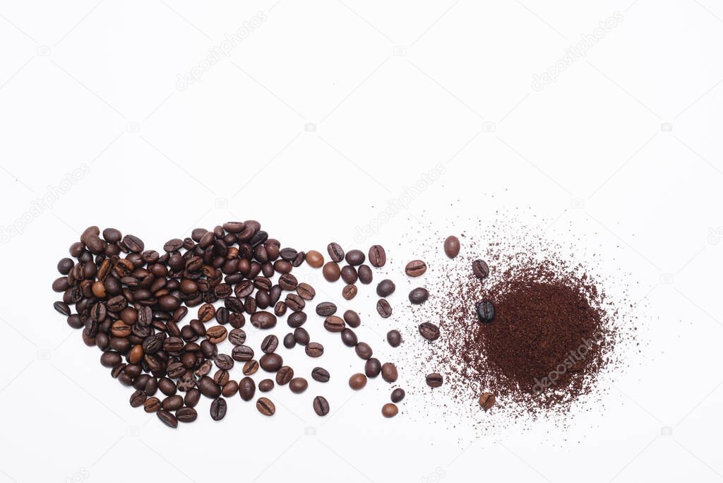 Heart made of coffee beans and ground coffee isolated on white background