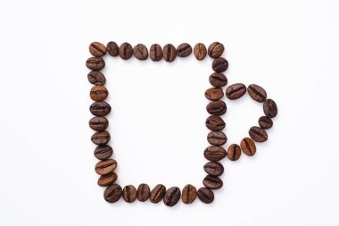 Sütlü kahve fincanı ve beyaz kahve çekirdekleri.