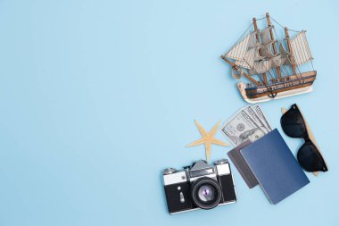 Geçmişe dönük kamera filmleri, akıllı telefon, harita, pasaport, pusula ve mavi arka planda gezgin kıyafeti içeren seyahat konsepti kopya alanı, turist gereksinimleri, klasik ton efekti
