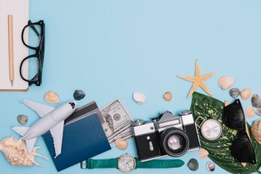 Geçmişe dönük kamera filmleri, akıllı telefon, harita, pasaport, pusula ve mavi arka planda gezgin kıyafeti içeren seyahat konsepti kopya alanı, turist gereksinimleri, klasik ton efekti