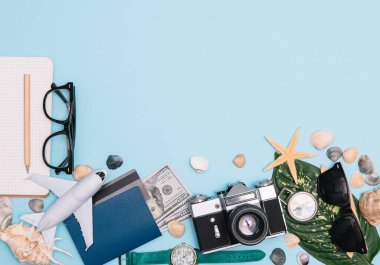 Geçmişe dönük kamera filmleri, akıllı telefon, harita, pasaport, pusula ve mavi arka planda gezgin kıyafeti içeren seyahat konsepti kopya alanı, turist gereksinimleri, klasik ton efekti