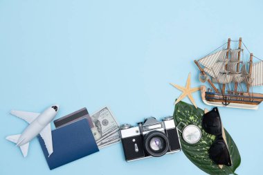 Geçmişe dönük kamera filmleri, akıllı telefon, harita, pasaport, pusula ve mavi arka planda gezgin kıyafeti içeren seyahat konsepti kopya alanı, turist gereksinimleri, klasik ton efekti