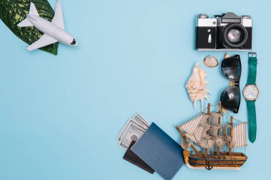 Geçmişe dönük kamera filmleri, akıllı telefon, harita, pasaport, pusula ve mavi arka planda gezgin kıyafeti içeren seyahat konsepti kopya alanı, turist gereksinimleri, klasik ton efekti