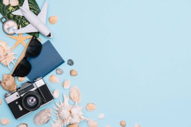 Seyahat konsepti, saat, uçak, para, pasaport, kalem, kitap, fotoğraf çerçevesi, mavi arkaplanda fotokopi alanı olan gözlük hazırlığı.