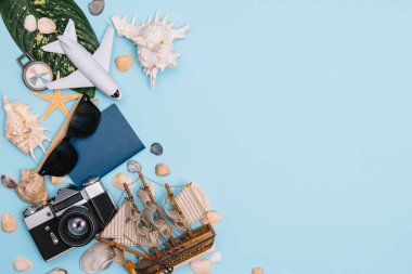 Seyahat konsepti, saat, uçak, para, pasaport, kalem, kitap, fotoğraf çerçevesi, mavi arkaplanda fotokopi alanı olan gözlük hazırlığı.