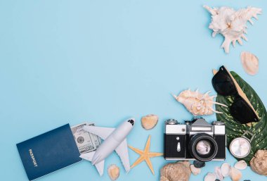 Seyahat konsepti, saat, uçak, para, pasaport, kalem, kitap, fotoğraf çerçevesi, mavi arkaplanda fotokopi alanı olan gözlük hazırlığı.