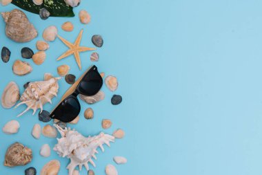 Plaj aksesuarları. Havlu, parmak arası terlik, denizyıldızı, tahta arka planda tekne ve güneş gözlüğü. Kopyalama alanı olan üst görünüm. Güneşli tonlu