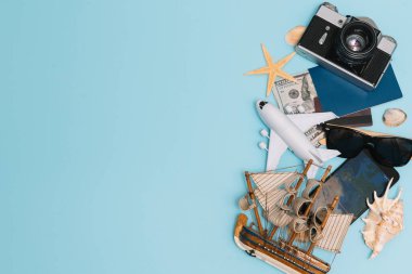 Geçmişe dönük kamera filmleri, akıllı telefon, harita, pasaport, pusula ve mavi arka planda gezgin kıyafeti içeren seyahat konsepti kopya alanı, turist gereksinimleri, klasik ton efekti