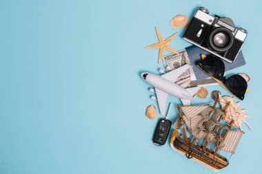 Geçmişe dönük kamera filmleri, akıllı telefon, harita, pasaport, pusula ve mavi arka planda gezgin kıyafeti içeren seyahat konsepti kopya alanı, turist gereksinimleri, klasik ton efekti