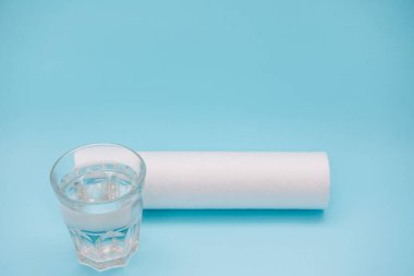 Su filtreleri. Karbon kartuşlar ve mavi zemin üzerinde su olan bir bardak. Ev filtreleme sistemi.
