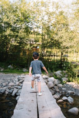 Genç anne ve küçük oğlu seyahat ediyorlar. Anne çocukla gezintiye çıktı, aile gezisi dağlarda. Ulusal Park. Çocuklarla yürüyüş. Aktif yaz tatili. Fisheye merceği