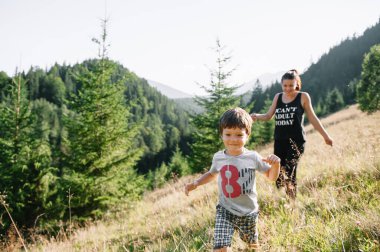 Genç anne ve küçük oğlu seyahat ediyorlar. Anne çocukla gezintiye çıktı, aile gezisi dağlarda. Ulusal Park. Çocuklarla yürüyüş. Aktif yaz tatili. Fisheye merceği