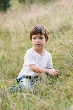 Küçük çocuk bir dağ köyünün yakınında yürüyor.
