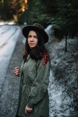 Dağ yolunda arka planda şapkası olan mutlu bir kız, tatil konsepti seyahatinde dinlenme zamanı, klasik ton rengi ve yumuşak odaklanma.