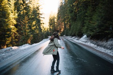 Dağ yolundaki ormanda şapkalı bir kızın fotoğrafı. Tatil konsepti seyahatinde gevşeme zamanı, klasik ton rengi ve yumuşak odak