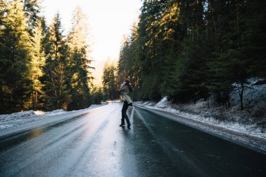 Dağ yolundaki ormanda şapkalı bir kızın fotoğrafı. Tatil konsepti seyahatinde gevşeme zamanı, klasik ton rengi ve yumuşak odak