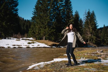 Ormanda gezen şık bir kız. Yaz ormanlarında gezen şapkalı genç bir kadın nehire bakıyor. Seyahat ve seyahat tutkusu konsepti. Metin için boşluk