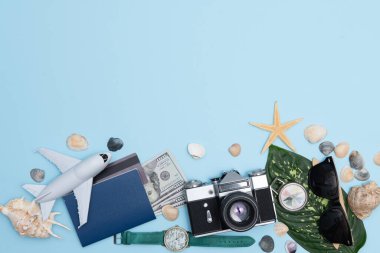 Seyahat konsepti, saat, uçak, para, pasaport, kalem, kitap, fotoğraf çerçevesi, mavi arkaplanda fotokopi alanı olan gözlük hazırlığı.
