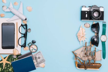 Geçmişe dönük kamera filmleri, akıllı telefon, harita, pasaport, pusula ve mavi arka planda gezgin kıyafeti içeren seyahat konsepti kopya alanı, turist gereksinimleri, klasik ton efekti