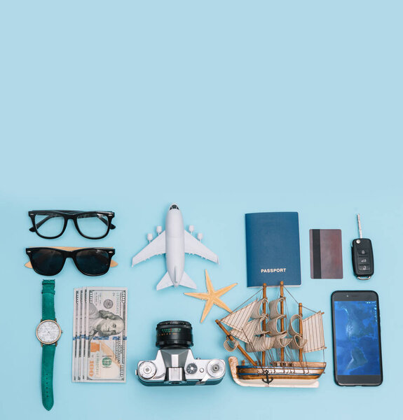 вид сверху концепция путешествия с ретро камеры фильмов, смартфон, карта, паспорт, компас и снаряжение путешественника на синем фоне с копировальным пространством, туристические предметы первой необходимости, винтажный эффект тон