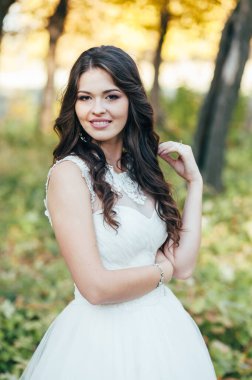 Güzel mutlu gelin gün batımında dışarıda. Güzel kadın. Beyaz elbiseli güzel gelin. Seksi bir gelin. Gelin portresi. Makyaj, saç stili, moda..