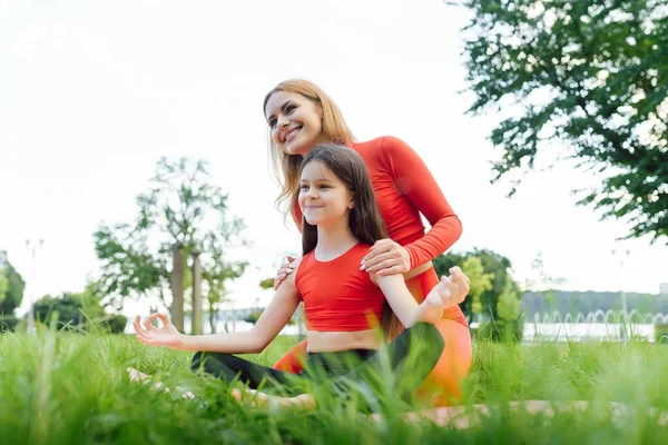 昼間は公園の芝生でヨガの練習をしている母と娘 屋外で楽しんでいる人 フレンドリーな家族と夏休みの概念 — ストック写真