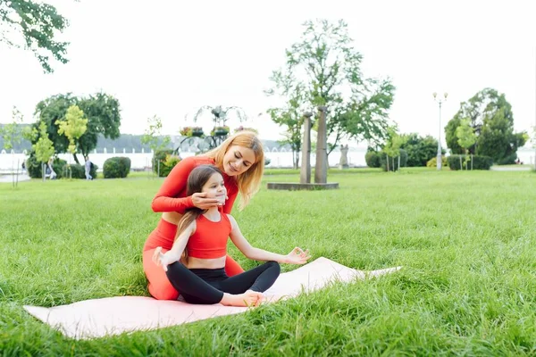 母と娘は公園で芝生の上でヨガの練習をしています — ストック写真