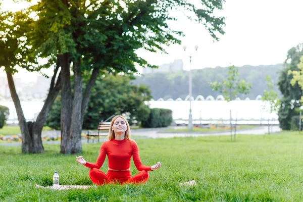 緑の公園でヨガの練習をしている若い女性 — ストック写真
