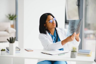 Güzel bir Afrikalı doktor. Röntgen cihazı tutuyor.