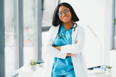 Hastanede gülümseyen Afrikalı Amerikalı kadın doktor portresi.