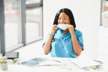 Yüz maskeli çekici bir Afrikalı doktor.