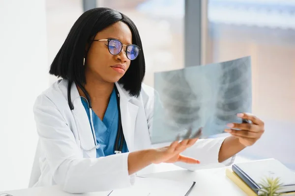 beautiful female african medical worker holding x-ray