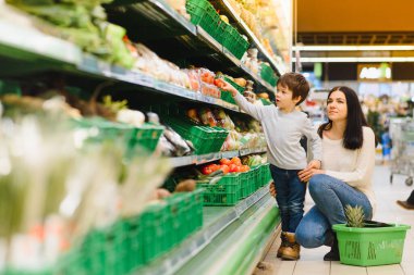 Kadın ve çocuk süpermarkette aile alışverişi yaparken