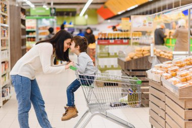 Kadın ve çocuk süpermarkette aile alışverişi yaparken