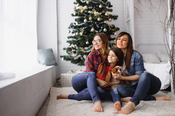 크리스마스 휴일에는 여자와 키우는 소녀가 크리스마스 근처에서 즐거운 시간을 보낸다 — 스톡 사진