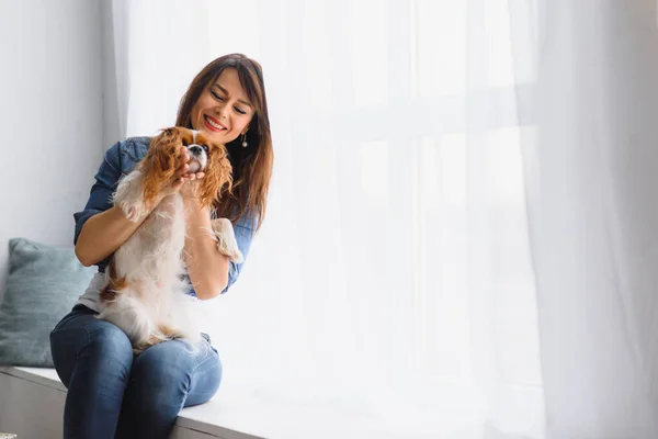 Lächelnde Frau Umarmt Einen Niedlichen Hund Der Aus Dem Fenster — Stockfoto