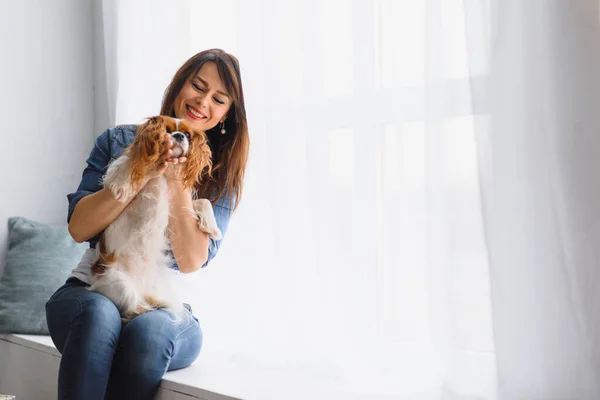 Mujer Sonriente Abrazando Lindo Perro Mirando Por Ventana — Foto de Stock