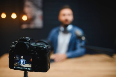 Video blogcusu, stüdyoda profesyonel bir kamera kullanarak çevrimiçi izleyiciler için ilgi çekici videolar yaratıyor.