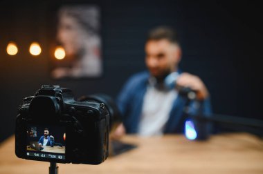 İçerik oluşturucu profesyonel ekipman, kamera, mikrofon ve dizüstü bilgisayar kullanarak ev stüdyosunda video blogu kaydediyor