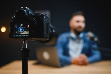 Modern bir stüdyo ortamında profesyonel bir kamera ve mikrofon kullanırken içeriği yakalayan video blogcu