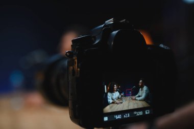 Profesyonel bir stüdyoda podcast kaydeden iki içerikli yaratıcı, konuşmayı kamerayla kaydediyor.