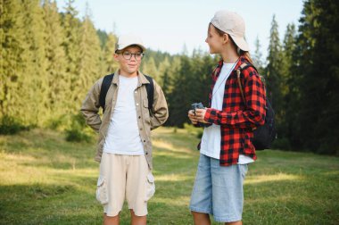 Yaz tatilinin tadını çıkaran iki genç izci, ağaçlar ve vahşi yaşamla dolu canlı yeşil bir ormanı keşfediyor, neşe ve keşif anlarını paylaşıyorlar.