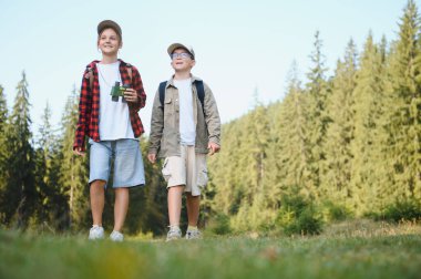 İki genç izci, zengin bir ormanda gezintiye çıkmışlar. Sırt çantaları ve dürbünleriyle maceraya hazırlar.