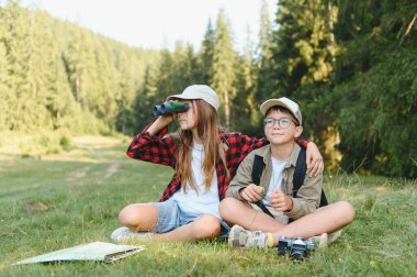 Çocuklar maceradan zevk alıyor, dürbün ve haritayla doğayı keşfediyor, takım çalışmasını teşvik ediyor ve açık havaya değer veriyor.