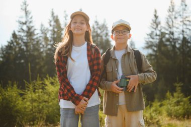 Sırt çantalı iki genç turist yaz tatilinin tadını çıkarıyorlar. Bereketli bir ormanda yürüyüş yapıyorlar. Macera ve doğayı kucaklıyorlar.